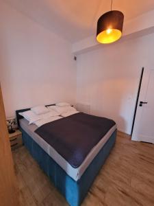 a bedroom with a bed with a black blanket and a light at Cicha 3 in Sztutowo