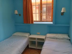 two beds in a room with a window at Apartamentos Jasmund - Bungalow 87 in San Fernando
