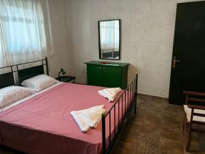 ネア・フォケアにあるGreen House in the Seaのベッドルーム1室(ピンクのシーツと鏡付きのベッド1台付)