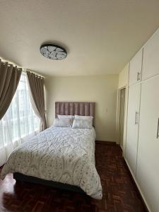 Un dormitorio con una cama y una ventana grande. en Florida, en Durban