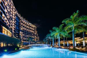 a swimming pool with palm trees and a building at Savoy Palace - The Leading Hotels of the World - Savoy Signature in Funchal