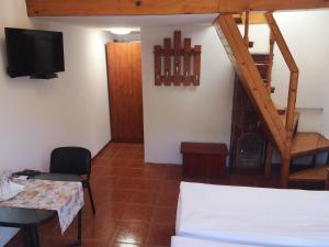 un soggiorno con tavolo, TV e scala di Aterman's Cottages a Perşani