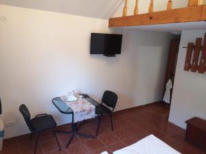 una camera con tavolo, sedie e TV a parete di Aterman's Cottages a Perşani Altre 11 foto