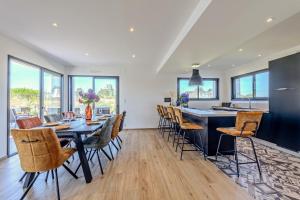 a kitchen and dining room with a table and chairs at Ti Braz Magnifique Maison Piscine in Plouguerneau