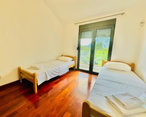 a room with two beds and a large window at Orahovac sunny port in Kotor