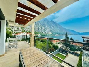 a balcony with a view of the water and mountains at Orahovac sunny port in Kotor