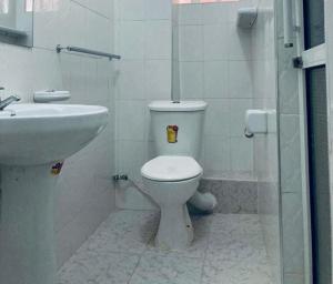 une salle de bains blanche avec toilettes et lavabo dans l'établissement Thika Furnished Apartments, à Thika