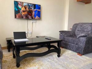un salon avec un canapé et une table avec un ordinateur portable dans l'établissement Thika Furnished Apartments, à Thika