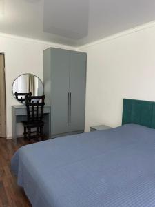 a bedroom with a bed and a desk and a cabinet at Laguna City Lux in Tegirmenty +39 photos