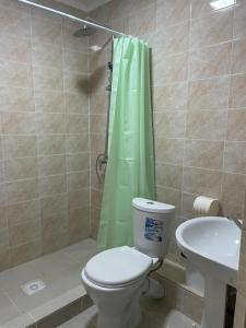 a bathroom with a toilet and a shower and a sink at Laguna City Lux in Tegirmenty