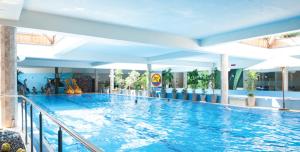a large swimming pool with people in the water at VacationClub - Komuny Paryskiej 30 Apartament 3 in Karpacz
