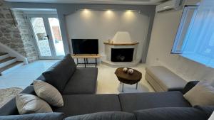 Una sala de estar con un sofá y una chimenea. en Villa Vista, en Asprogerakata