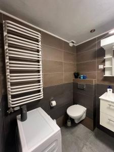 a bathroom with a white toilet and a sink at Cosy Rooms in Kraków