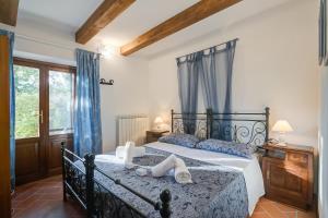 sypialnia z dużym łóżkiem z niebieskimi zasłonami w obiekcie Comfortable Home Romeo Among Greenery - Happy Rentals w mieście Borgo a Mozzano +35 zdjęć
