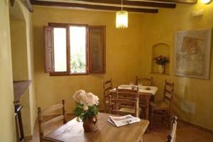 a dining room with a table with a vase of flowers on it at Casa Figueretes in Finestrat