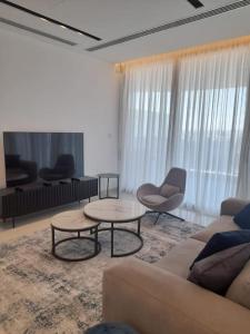 ein Wohnzimmer mit einem Sofa sowie 2 Tischen und Stühlen in der Unterkunft 360 Nicosia-2 Bedroom City Tower in Nikosia