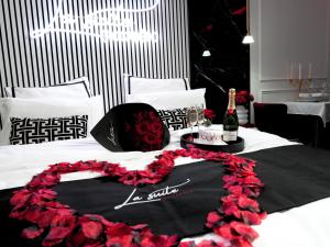 un letto con una composizione floreale nera e rossa di La Suite Trocadéro - Jacuzzi privatif a Parigi