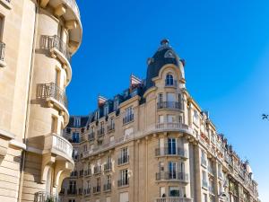 Un edificio con un orologio sopra. di La Suite Trocadéro - Jacuzzi privatif a Parigi