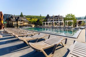 una piscina con sedie a sdraio e un mucchio di sedie di Guest House Turda a Bukovel