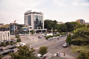 a busy city street with a tall building and cars at City Center INN in Shkodër