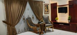 a hotel room with two chairs and a tv at Diplomat Fort Boutique Hotel in Karachi