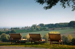 three benches sitting in the grass in a field at Château de Salettes in Cahuzac-sur-Vère