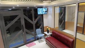 a living room with a red couch and a television at Hotel Fab International in Kolkata