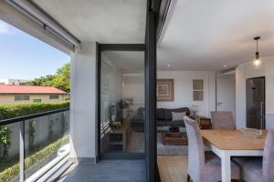 Central Southern Suburbs Leafy Village Neighbourhood في كيب تاون: غرفة طعام وغرفة معيشة مطلة على المياه