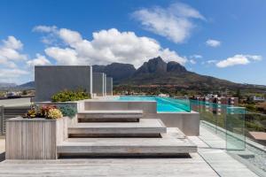 Central Southern Suburbs Leafy Village Neighbourhood في كيب تاون: منزل فيه درج ومسبح