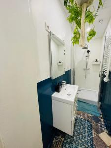 a bathroom with a white sink and a tub at Appartement Oasis de Confort in Tourcoing