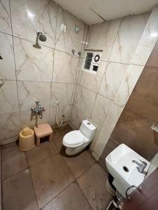 a bathroom with a toilet and a sink at Velan Temple View By PPH Living in Palani