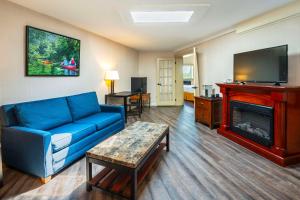 a living room with a blue couch and a fireplace at Hidden Valley Resort, Ascend Hotel Collection in Huntsville