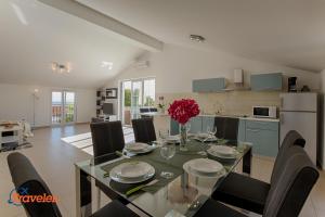a dining room and kitchen with a table and chairs at Luxury and modern villa with pool near beach by Traveler tourist agency Krk - ID 2138 in Vrh