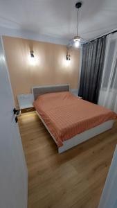 a bedroom with a bed with an orange bedspread at Matei Rent Apartments - Premium Stays & Free Parking in Baia Mare