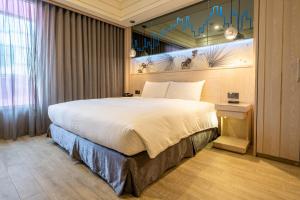 Rúm í herbergi á Guide Hotel Taichung Ziyou