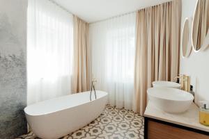 a white bathroom with two sinks and a tub and a toilet at Apartmánový dom BiSou - Trojičné námestie in Banská Štiavnica +52 photos
