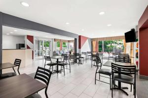 a dining room with tables and chairs and windows at Quality Inn Merrimack - Nashua in Merrimack