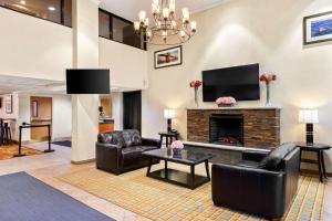 a living room with leather furniture and a fireplace at Quality Inn Edison-New Brunswick in Edison