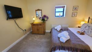 a bedroom with a bed with two towels on it at The Garden Room in Hednesford
