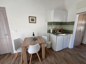 Apartmani Mareta في بتروفاتس نا مورو: مطبخ صغير مع طاولة خشبية وكراسي بيضاء