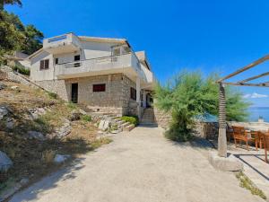 a house on a hill next to the ocean at Robinson Merlot in Bogomolje