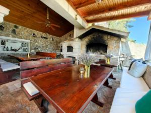 a patio with a wooden table and a stone fireplace at Robinson Merlot in Bogomolje