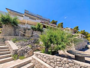 a building on a hill with stairs and trees at Robinson Merlot in Bogomolje