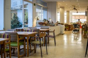 un restaurante con mesas y sillas en una cafetería en Espanya - 30º hotels, en Calella