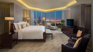 a large hotel room with a bed and a television at Kempinski Al Othman Hotel Al Khobar in Al Khobar