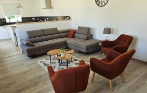 a living room with a couch and chairs and a table at Old Farmhouse in Chaumesnil