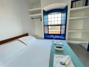 Un dormitorio pequeño con una cama y una ventana. en Brisa da Praia Colonial, en Ubatuba