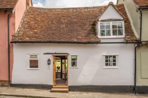 ein weißes Haus mit brauner Tür auf einer Straße in der Unterkunft Brimming with Medieval charm - Weavers Cottage in Lavenham