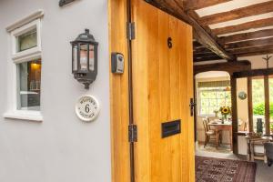 eine Tür zu einem Haus mit einer Uhr drauf in der Unterkunft Brimming with Medieval charm - Weavers Cottage in Lavenham + 28 Fotos