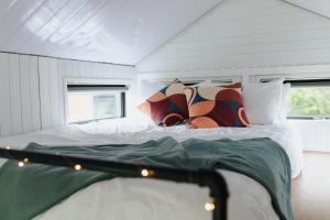 a bedroom with a bed with white sheets and pillows at Sweet Hart 1 by Tiny Away in Tamahere